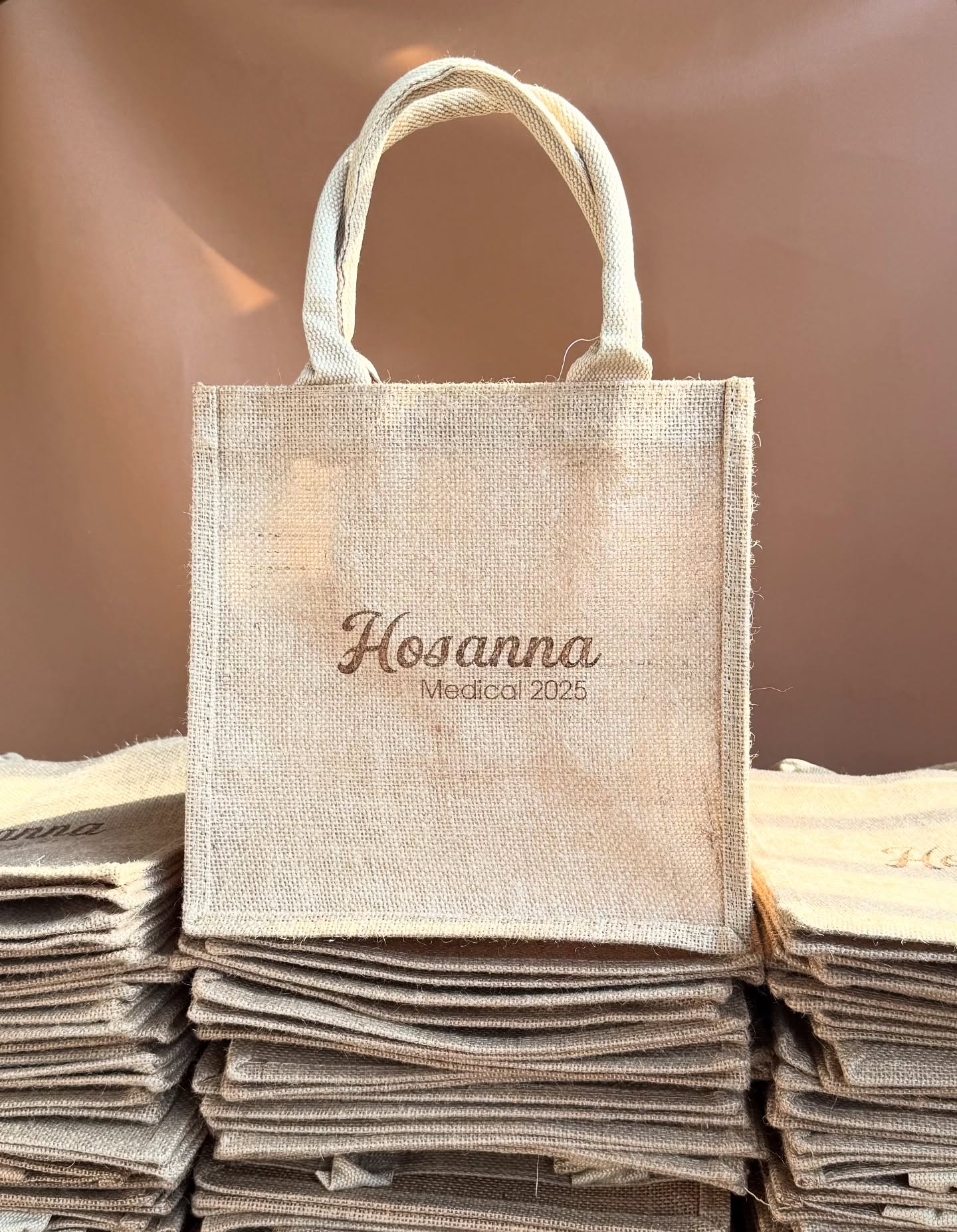 Jute bags laser engraved with the Hosanna Medical 2025 logo